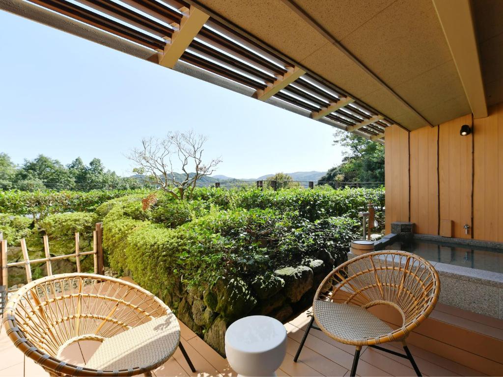 deux chaises et une table sur un balcon avec vue dans l'établissement Seizan Yamato, à Itō