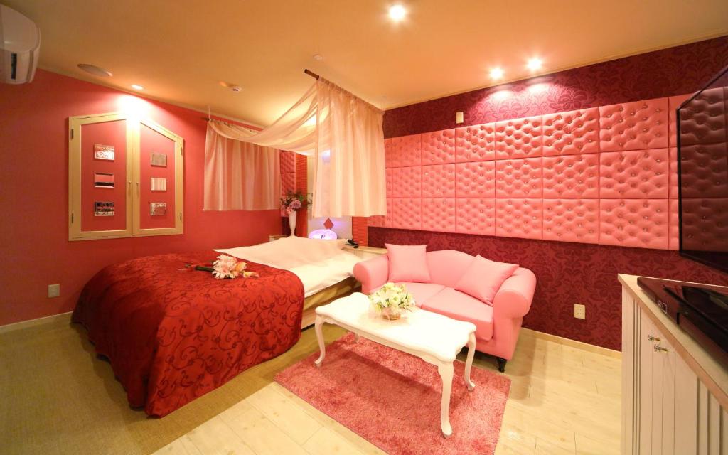 une chambre d'hôtel avec un lit et un canapé dans l'établissement ホテル フェアリー岩槻 Adult only, à Saitama