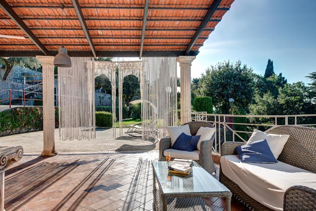 une terrasse avec un canapé et une table dans l'établissement Villa Demetra Capri - Pool and Relaxation, à Anacapri