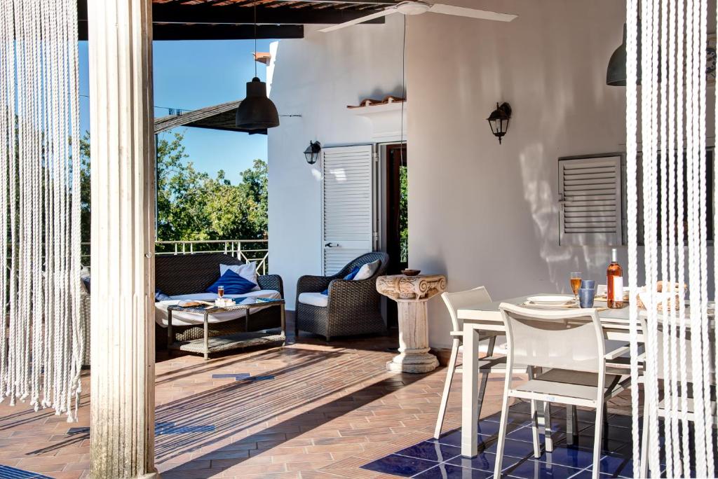 un patio avec une table, des chaises et un canapé dans l'établissement Villa Demetra Capri - Pool and Relaxation, à Anacapri