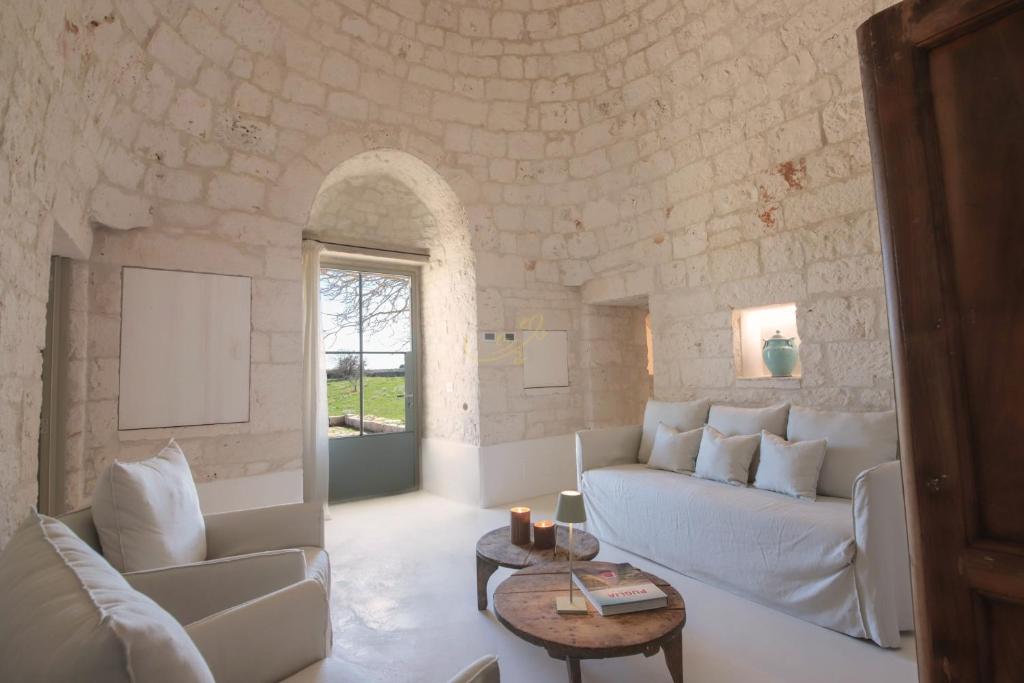 un salon avec un canapé blanc et une table dans l'établissement TD I Coni di Pinurè Trulli with Scenic Valley View, à Martina Franca