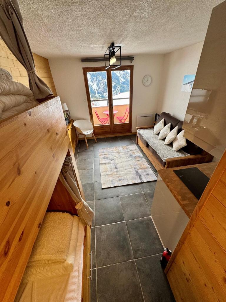un salon avec un canapé et une fenêtre dans l'établissement Le lodge by Lilou, à Manigod