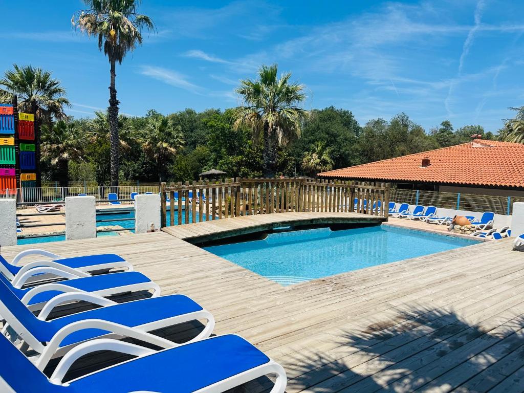 un groupe de chaises longues et une piscine dans l'établissement Mobile home op camping de Pujol in Argeles-Sur-Mer, à Argelès-sur-Mer