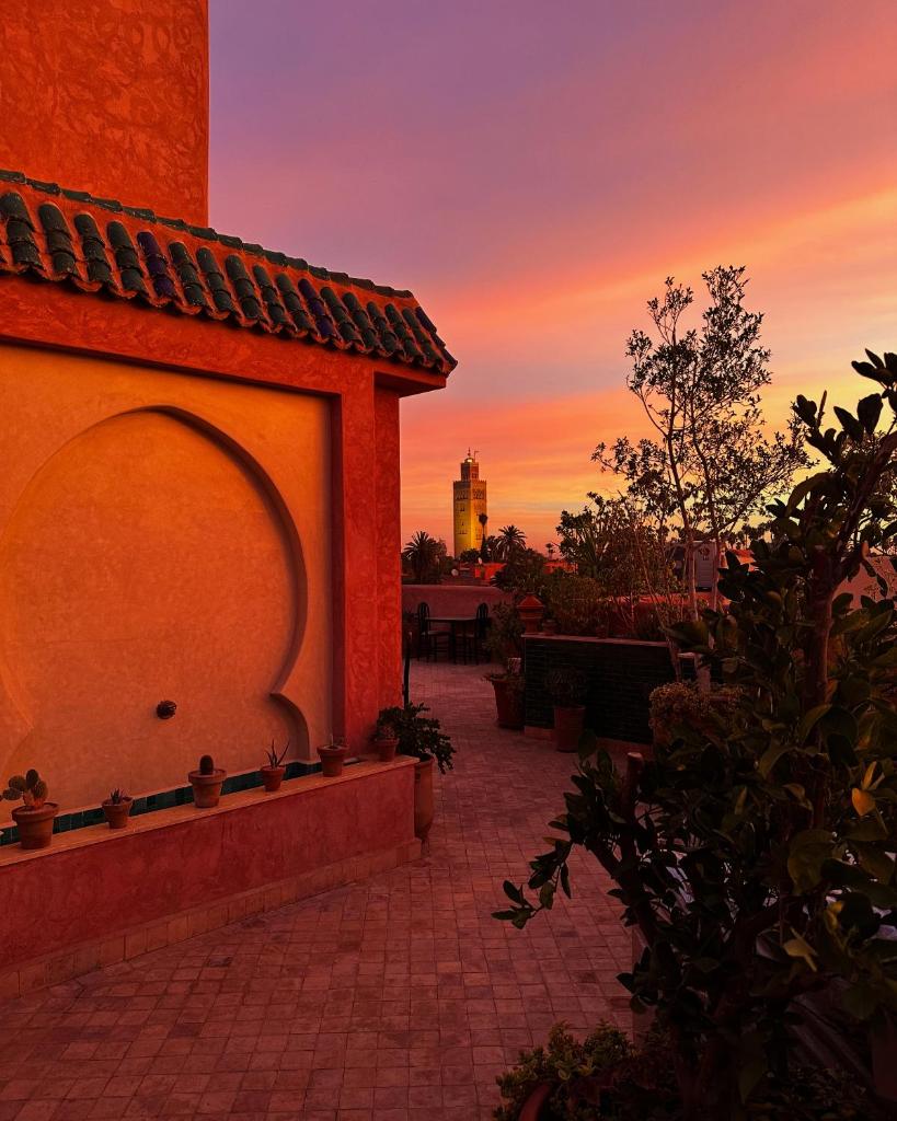un bâtiment avec un coucher de soleil en arrière-plan dans l'établissement Riad Atrium & Spa, à Marrakech