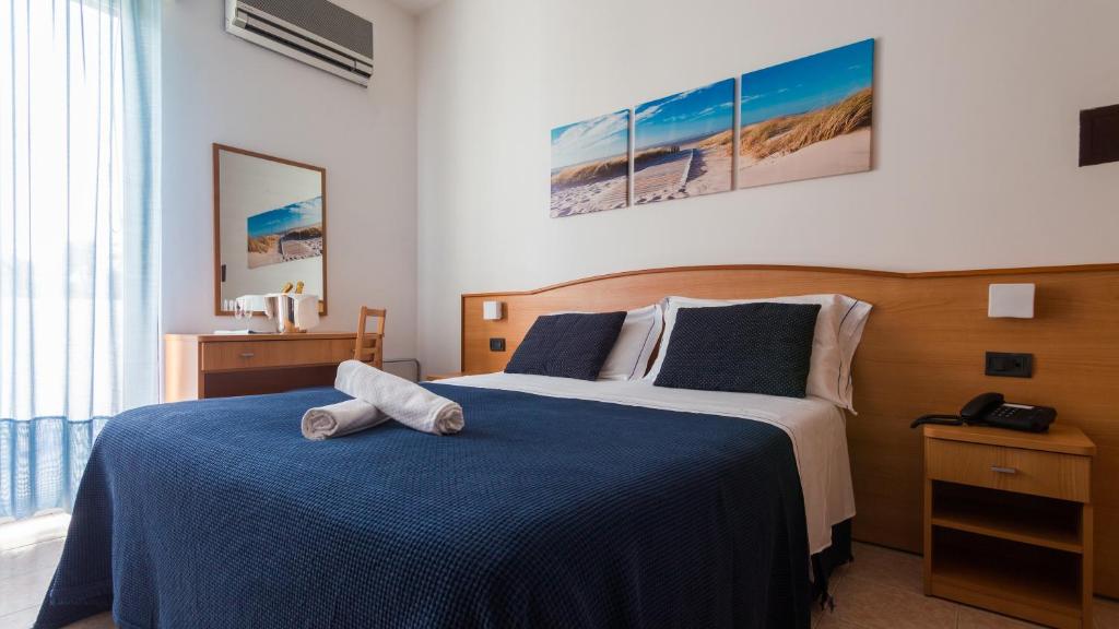 une chambre avec un grand lit avec une couverture bleue dans l'établissement Hotel Mare Blu -- boutique, à Pineto