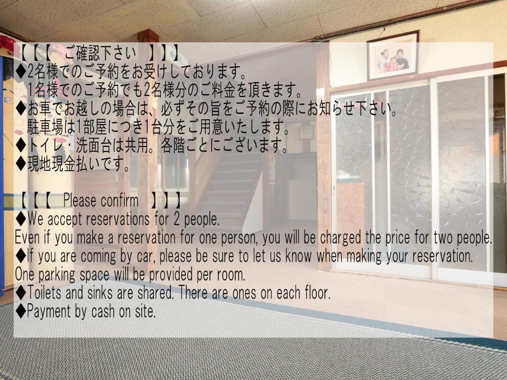 une fenêtre avec un signe sur celle-ci et un écrit sur celle-ci dans l'établissement Sunrise Meiji-ya, à Nozawa Onsen