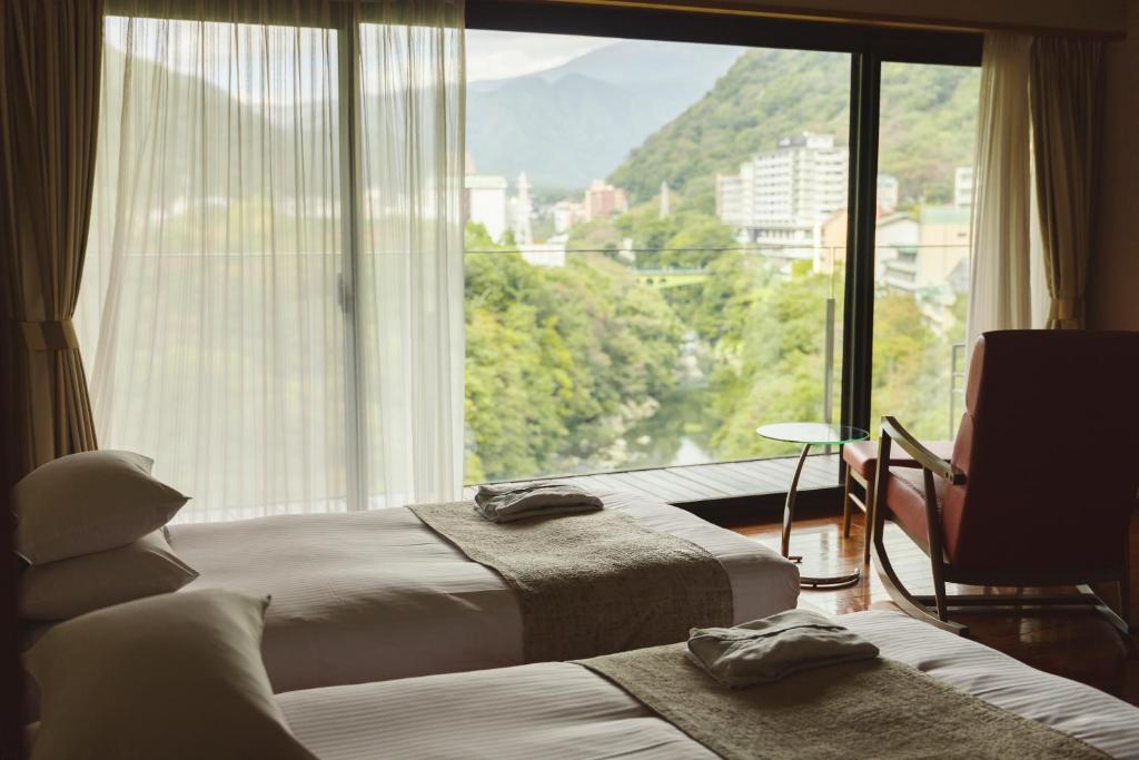 une chambre d'hôtel avec deux lits et une grande fenêtre dans l'établissement Kanaya Hotel Kinugawa, à Nikkō 36 autres photos
