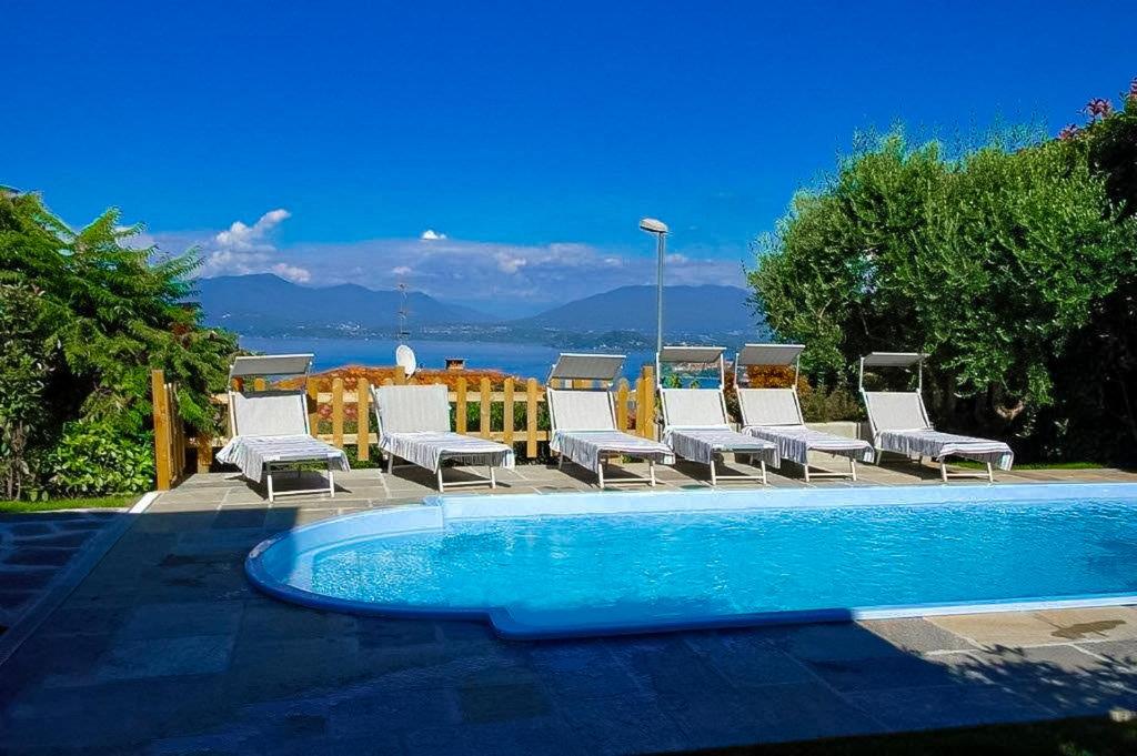 un groupe de chaises assises à côté d'une piscine dans l'établissement Villa Ametista, à Meina