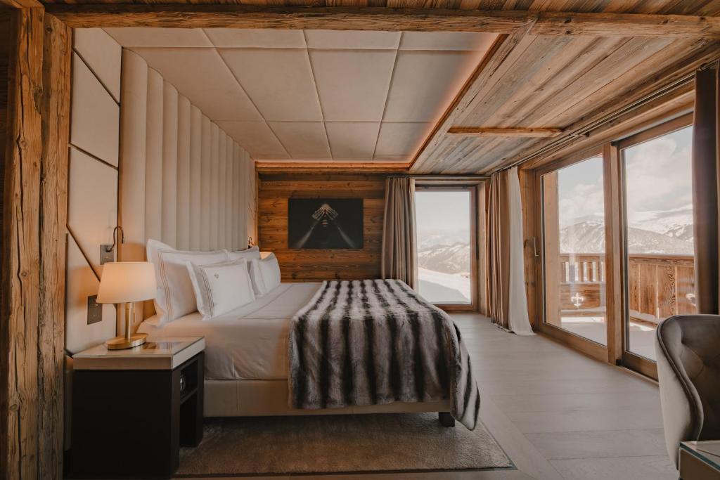une chambre avec un lit et une grande fenêtre dans l'établissement Ultima Hotel Courchevel, à Courchevel