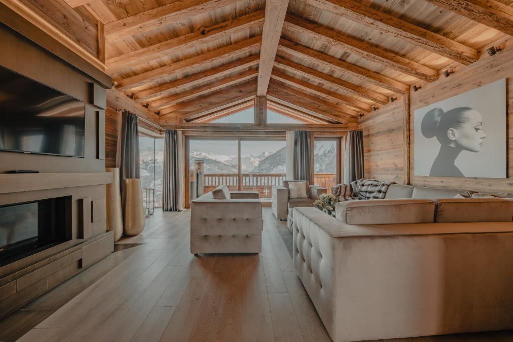 un salon avec un canapé et une télévision dans l'établissement Ultima Hotel Courchevel, à Courchevel
