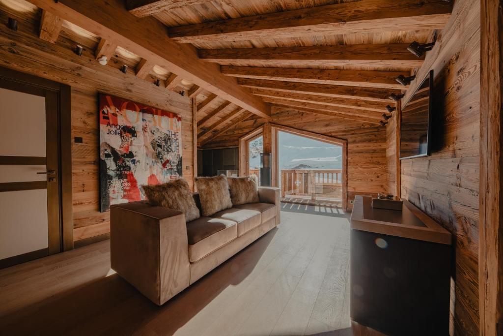 un salon avec un canapé et une télévision dans l'établissement Ultima Hotel Courchevel, à Courchevel