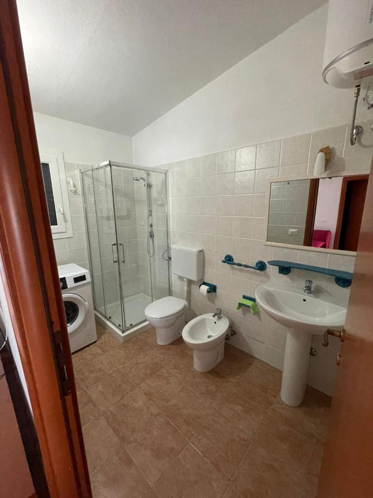 La salle de bains est pourvue de 2 toilettes, d'une douche et d'un lavabo. dans l'établissement Maracaibo Village, à Tarente