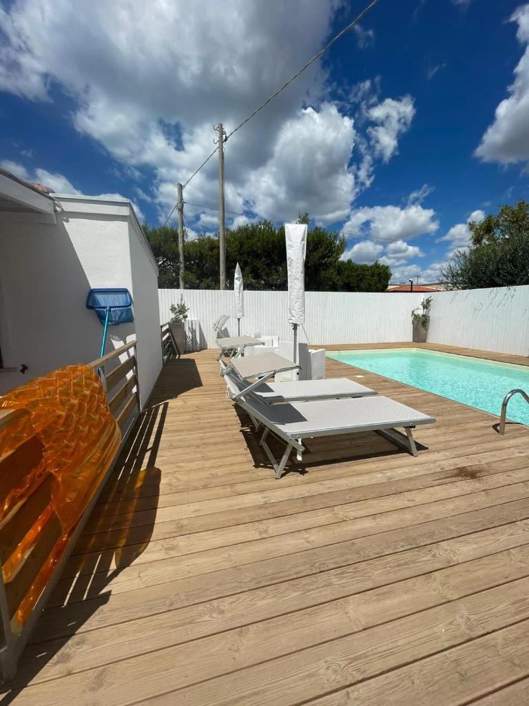 une terrasse avec des chaises longues et une piscine dans l'établissement Maracaibo Village, à Tarente