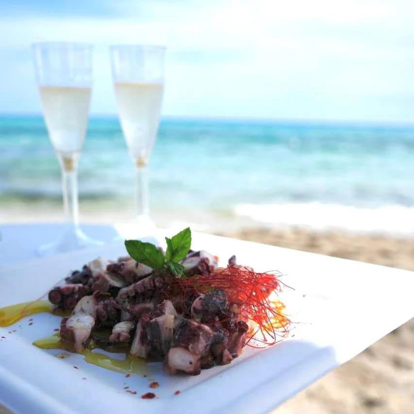 une assiette de nourriture à côté de deux verres d'eau dans l'établissement Maracaibo Village, à Tarente