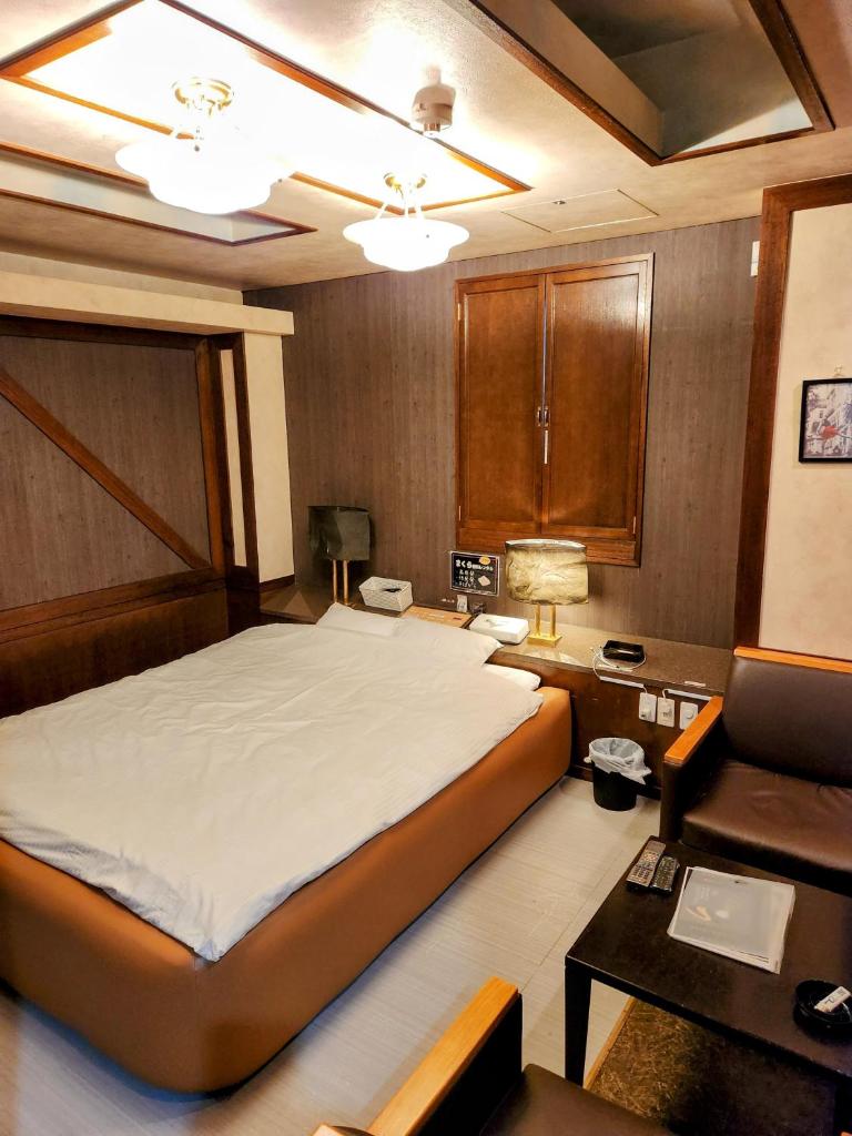 une chambre avec un grand lit et un bureau dans l'établissement ホテルQ adult only, à Kashiwazaki
