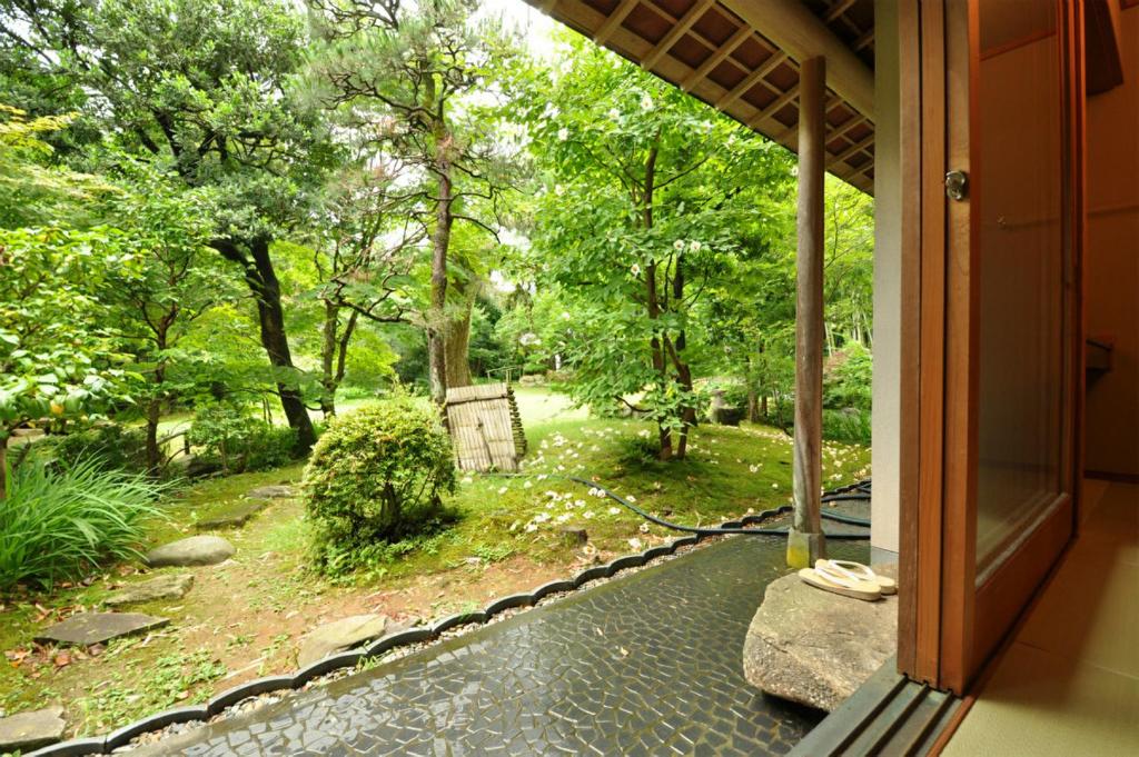 une vue d'un jardin depuis le porche d'une maison dans l'établissement Koshi no yado Takashimaya, à Niigata