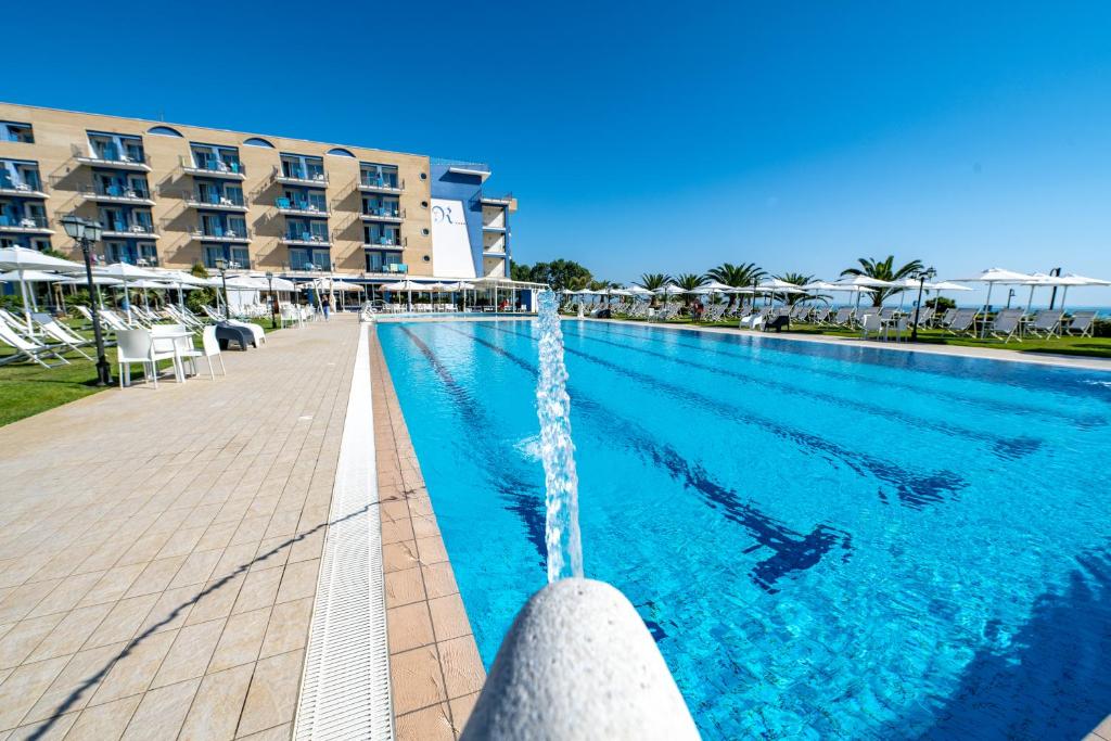 - une piscine avec une fontaine en face de l'hôtel dans l'établissement Roses Hotel, à Roseto degli Abruzzi