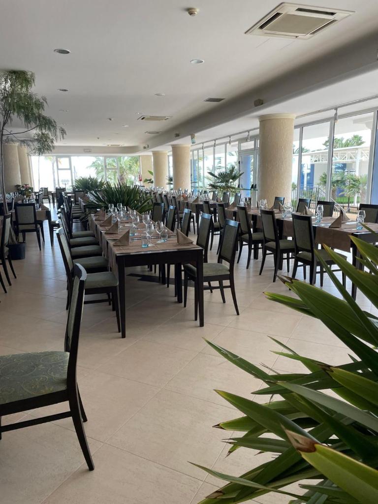 une salle à manger avec de longues tables et des chaises dans l'établissement Roses Hotel, à Roseto degli Abruzzi