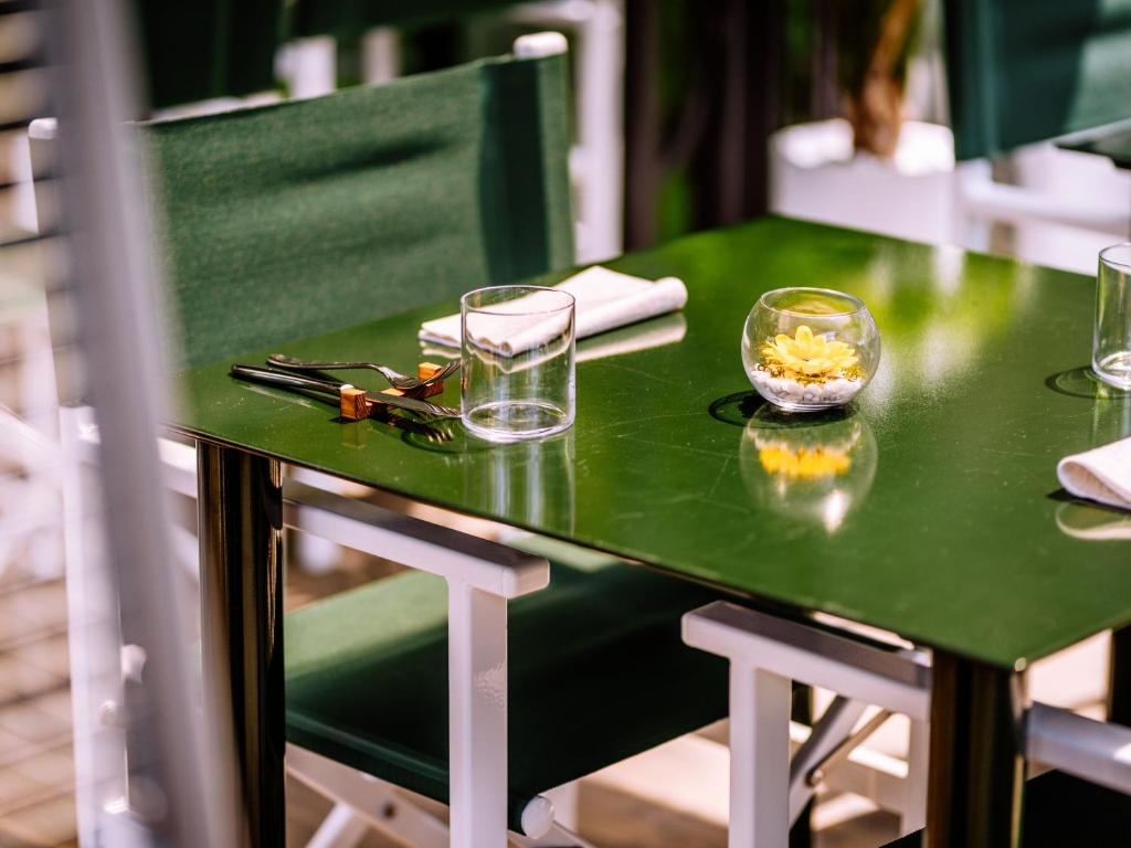 une table verte avec des verres en haut dans l'établissement Domus Plinii 1792 Suites, à Faggeto Lario