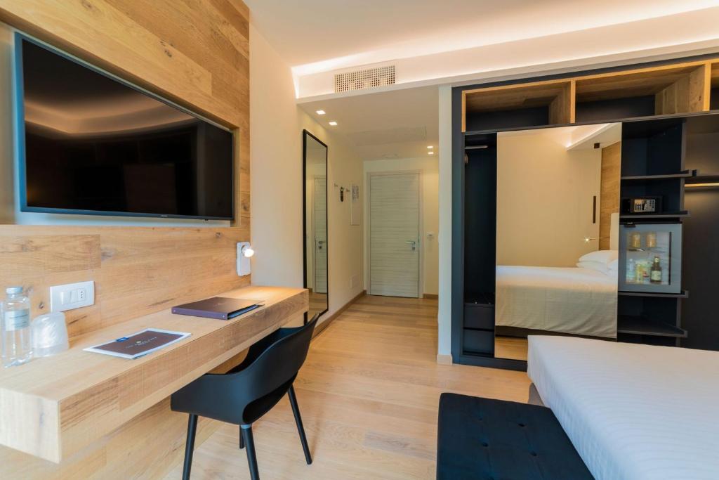 Cette chambre comprend un bureau, un lit et une chambre. dans l'établissement The Green Park Hotel WellnessSpa & Restaurant, à Cavallino-Treporti