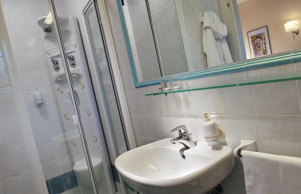 une salle de bain blanche avec lavabo et douche dans l'établissement Hotel San Giovanni Terme, à Ischia