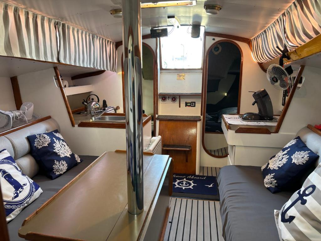 Cette petite chambre dispose d'un canapé et d'un lavabo. dans l'établissement Nuitée à bord de Danilou un voilier de 9.50m, à Sète