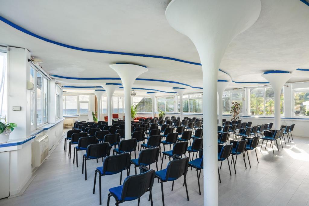 une grande salle avec des rangées de chaises et de tables dans l'établissement Apollon Club & Thermal Spa, à Ischia 102 autres photos
