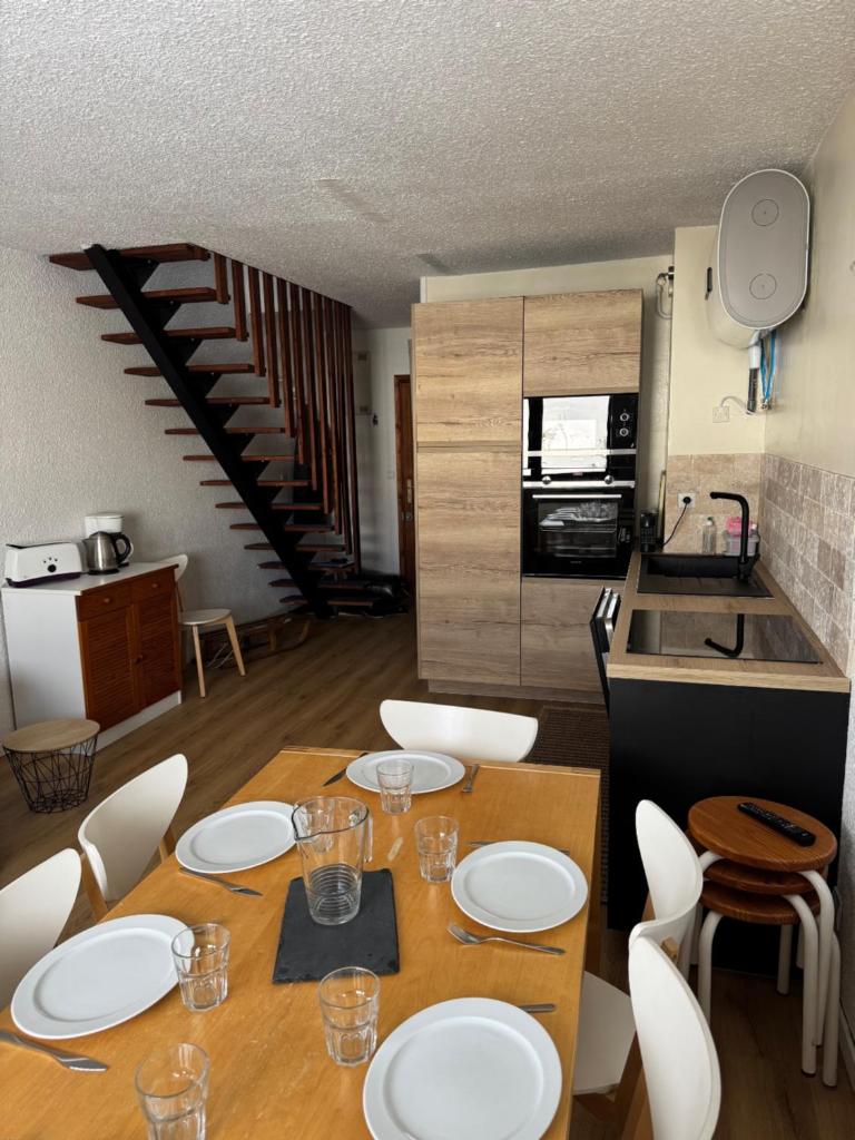 - une table à manger avec des plaques blanches dans la cuisine dans l'établissement Appartement Pla d'Adet Saint Lary classé 2 étoiles, à Saint-Lary-Soulan