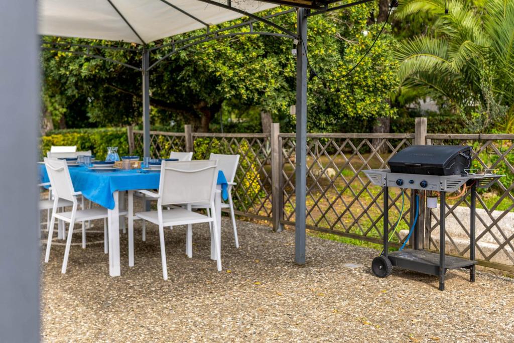 une table bleue et des chaises avec un grill, une table et des chaises dans l'établissement Villa Margherita, à Lecce