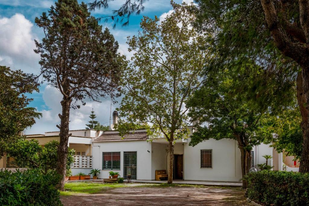 - une vue sur l'extérieur d'une maison blanche avec des arbres dans l'établissement Villa Margherita, à Lecce