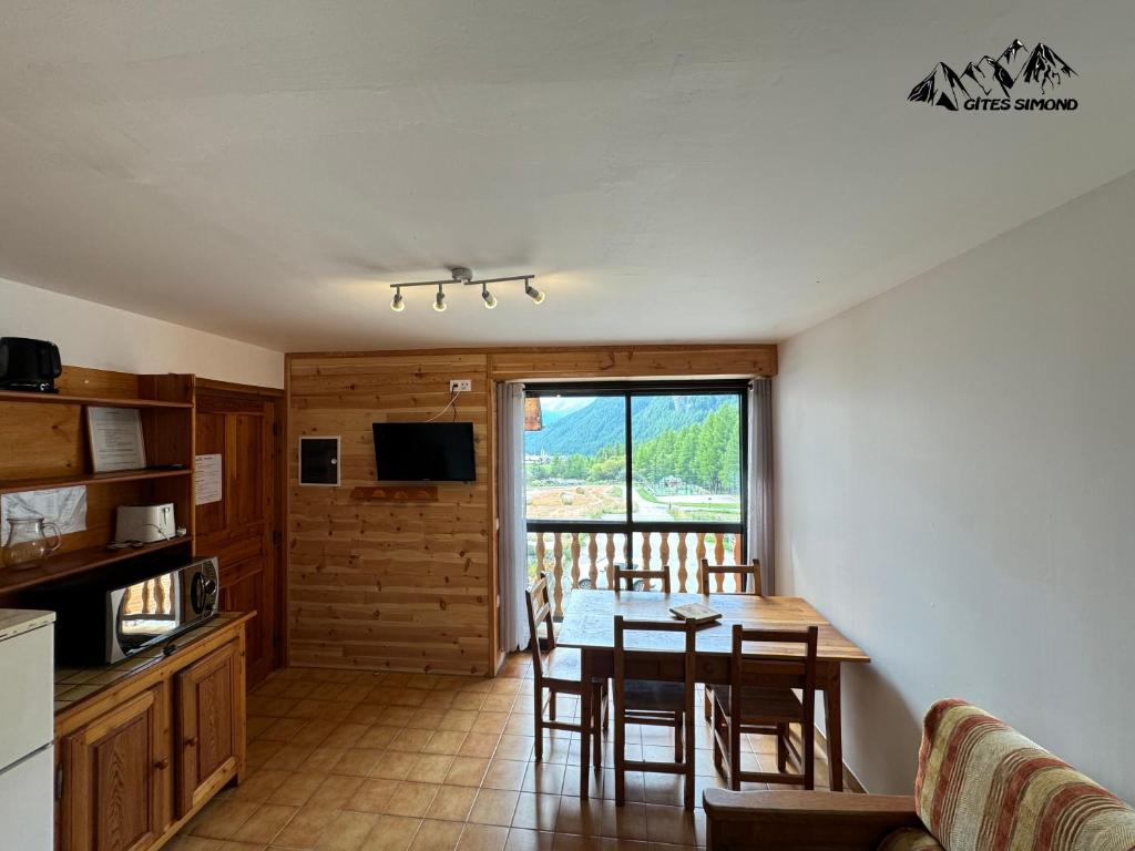 une cuisine et une salle à manger avec une table et des chaises dans l'établissement Gîtes Simond, à Arvieux 4 autres photos