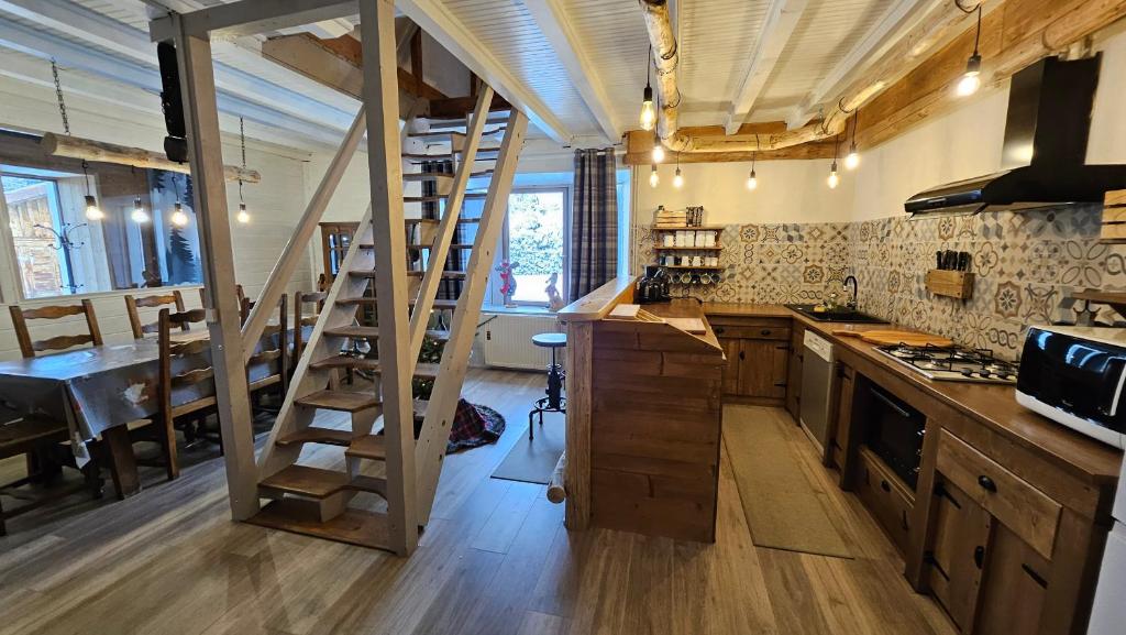 - une cuisine avec une échelle au milieu d'une pièce dans l'établissement Gîte du Grand Cher, aux Rousses