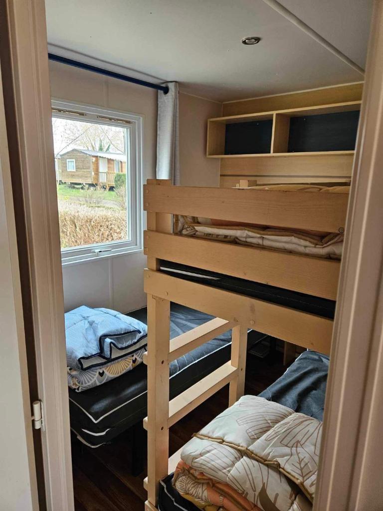 une chambre avec deux lits superposés et une fenêtre dans l'établissement Mobil home 6 personnes Alsace, à Biesheim 12 autres photos