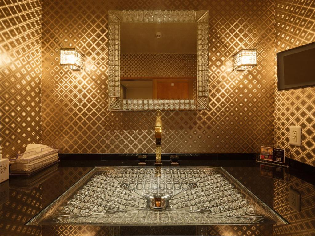 une salle de bain avec un lavabo et un miroir dans l'établissement Sekitaitei Ishida, à Achi
