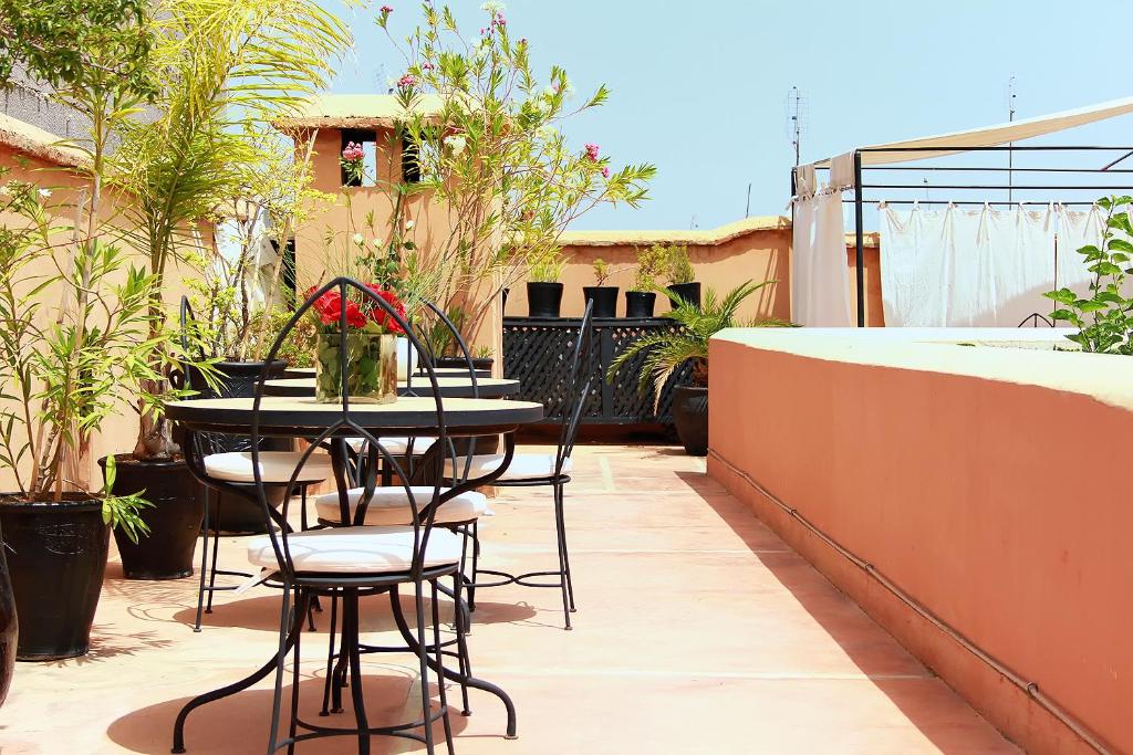 un patio avec une table et des chaises sur un balcon dans l'établissement Riad Davia, à Marrakech