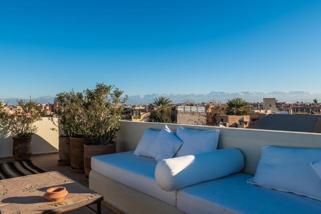 - un canapé bleu sur un balcon avec une table dans l'établissement Dar Mo'Da, à Marrakech