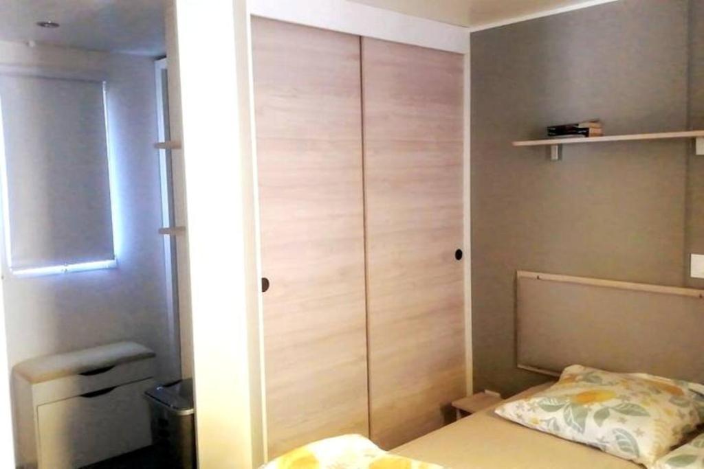 - une petite chambre avec un lit et un placard dans l'établissement Cosy et chaleureux, 2 ch, 2 sdb pour votre confort, super équipé, à Lattes