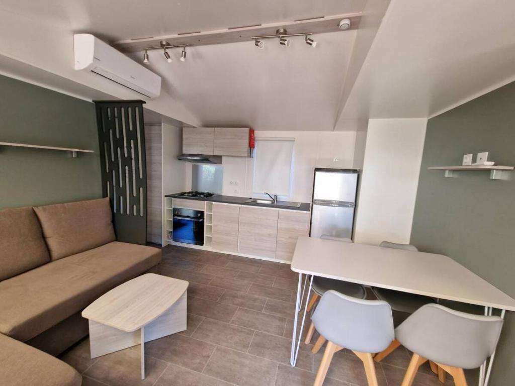 Il comprend une petite cuisine et un salon avec un canapé et une table. dans l'établissement Cosy et chaleureux, 2 ch, 2 sdb pour votre confort, super équipé, à Lattes