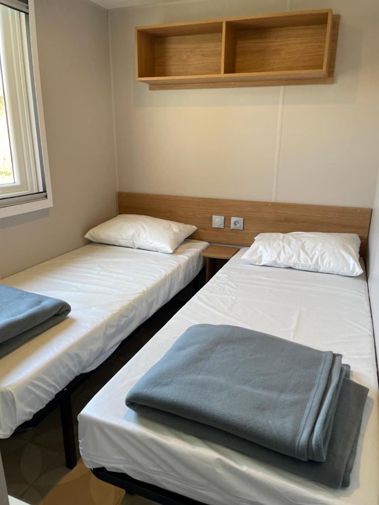 une chambre avec deux lits dans une pièce dans l'établissement Mobil-Home 1702, à Canet