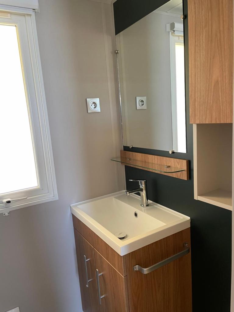 une salle de bain avec un lavabo et un miroir dans l'établissement Mobil-Home 1702, à Canet
