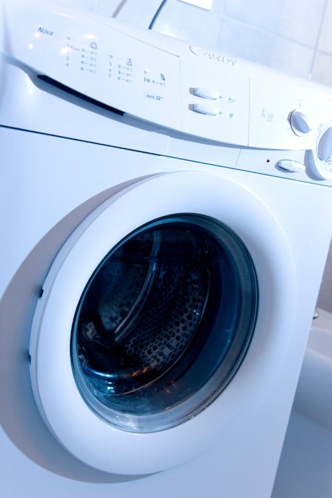 une machine à laver blanche avec sa porte ouverte dans l'établissement Villaggio Turistico Internazionale, à Porto Recanati