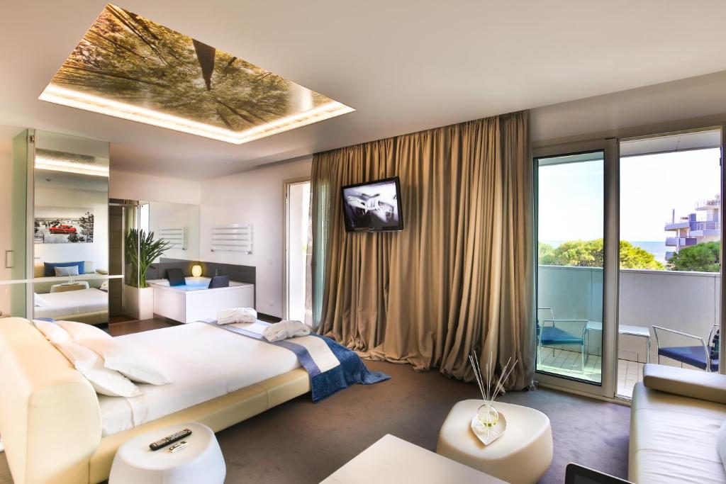 une chambre avec un grand lit et un balcon dans l'établissement Hotel Florida, à Lignano Sabbiadoro