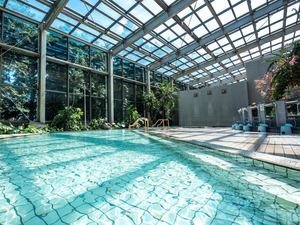 - une grande piscine dans un bâtiment doté d'un plafond en verre dans l'établissement Hotel Kirishima Castle, à Kirishima