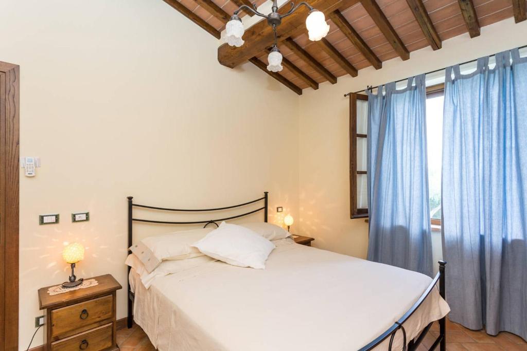une chambre avec un lit et une fenêtre avec des rideaux bleus dans l'établissement La Casa Del Sole, à Casamaggiore