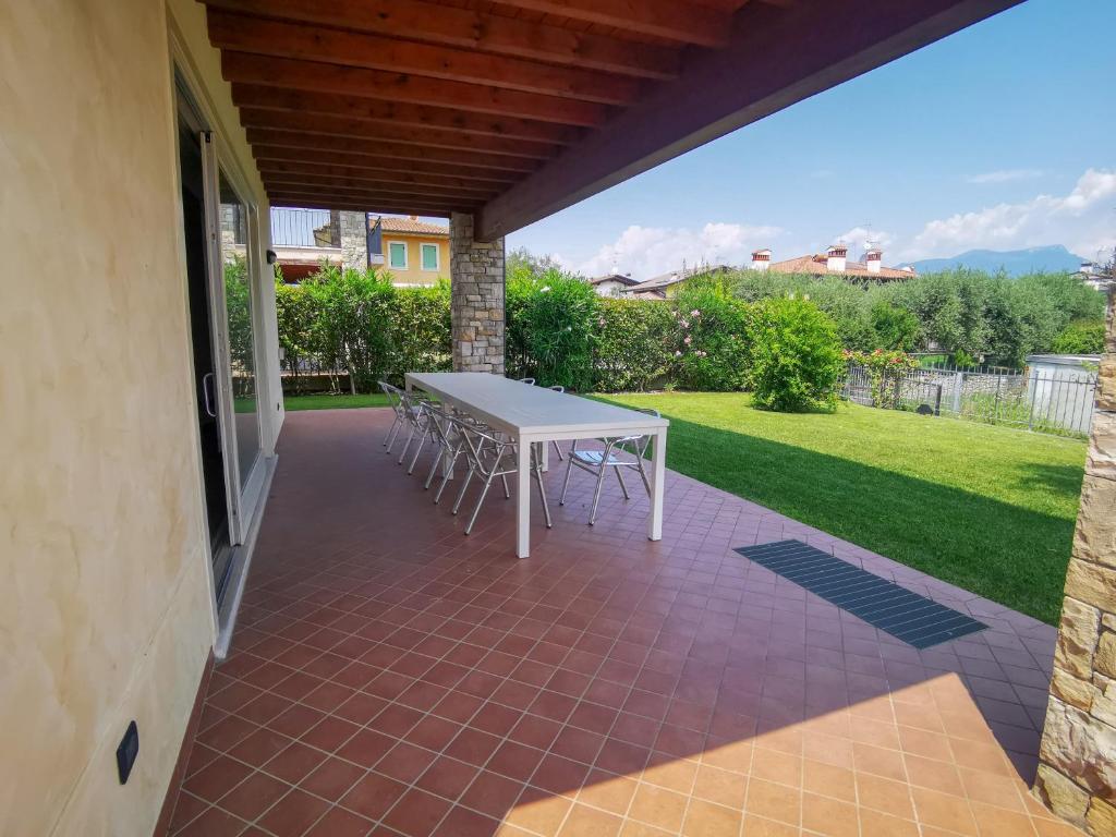 d'une terrasse avec une table et des chaises blanches. dans l'établissement Villa Garda Relax, à Manerba del Garda