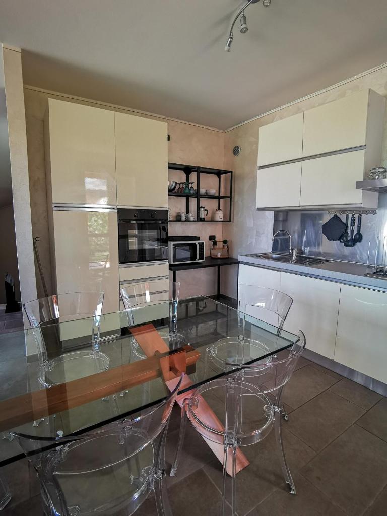 une cuisine avec une table et des chaises en verre dans l'établissement Villa Garda Relax, à Manerba del Garda
