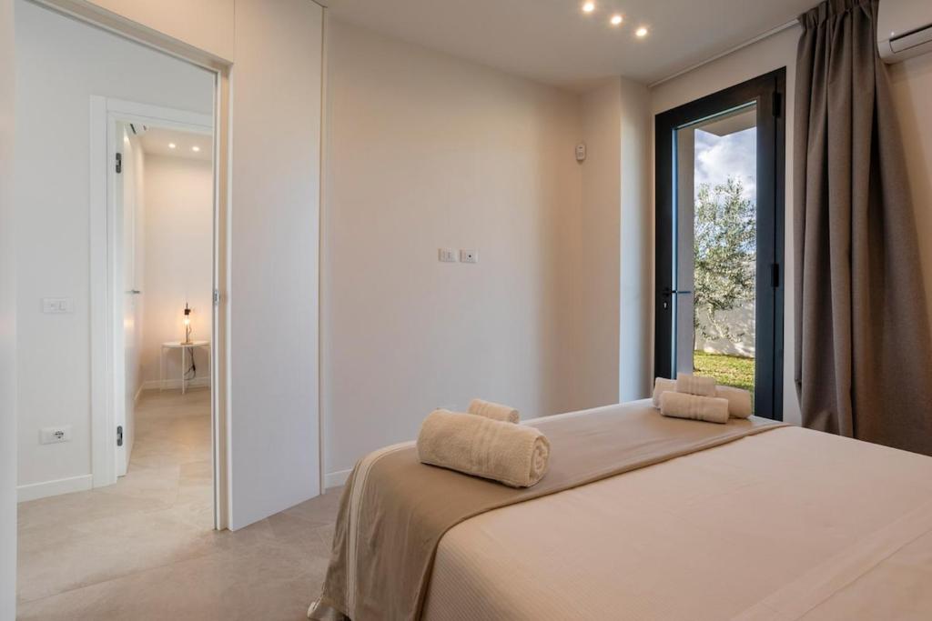 une chambre avec un grand lit et une grande fenêtre dans l'établissement Villa Nerissa - IsulaTravel, à Pozzallo 32 autres photos