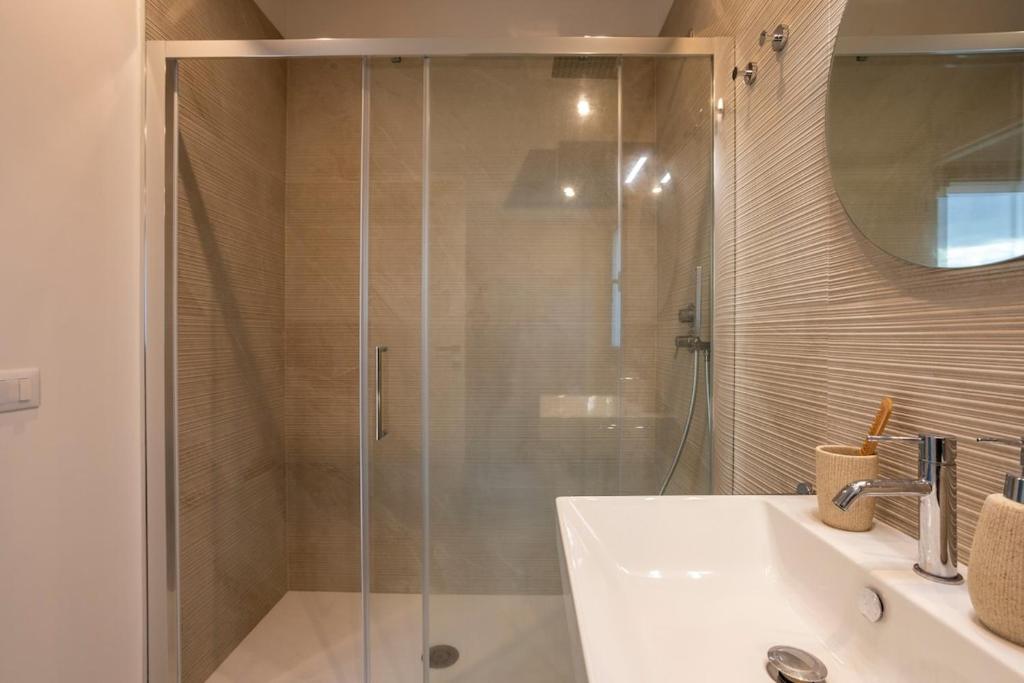 une salle de bain avec une douche en verre et un lavabo dans l'établissement Villa Nerissa - IsulaTravel, à Pozzallo