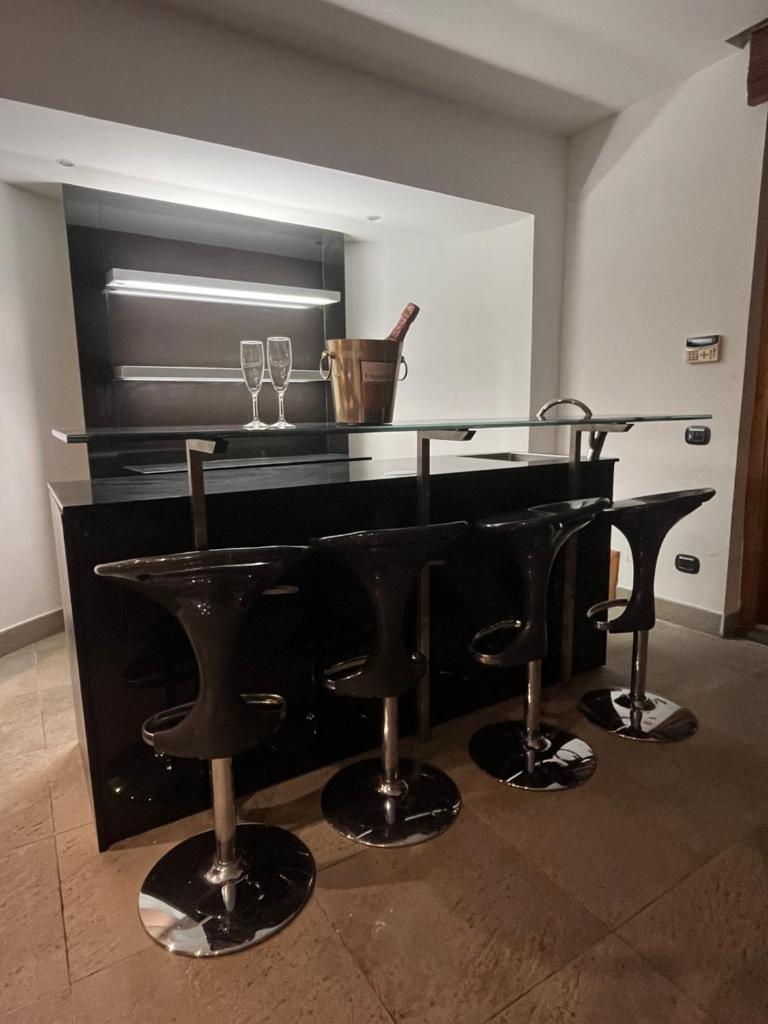 - un piano noir avec tabourets de bar dans une pièce dans l'établissement Villa Roma Open Space - Location per eventi 2 piscine riscaldate -, à Rome
