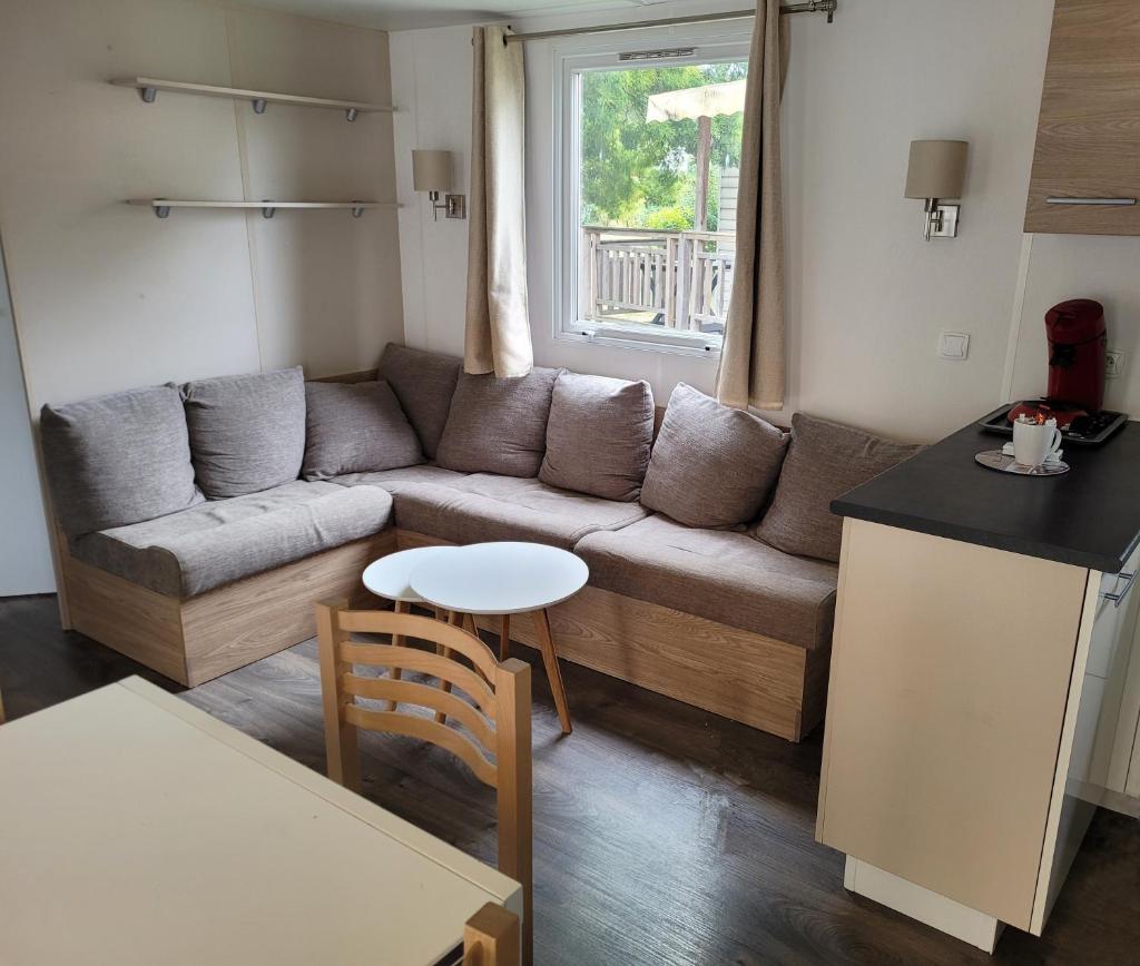 un salon avec un canapé et une table dans l'établissement VM-Mobile Home 3 ch, 2 sdb, Convivialité, détente et confort, en famille ou entre amis, à Lattes